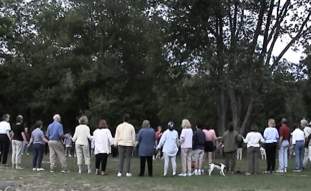 Circle of people and dogs among trees