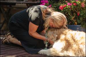 Woman leaning over golden dog