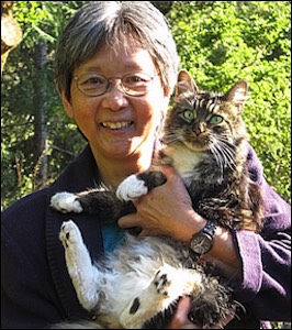 Woman holding green eyed tabby cat