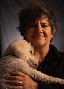 Woman smiling with poodle on chest