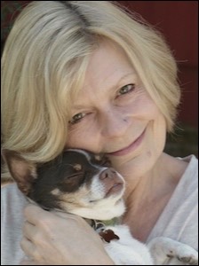 Woman smiling with dog tucked by face